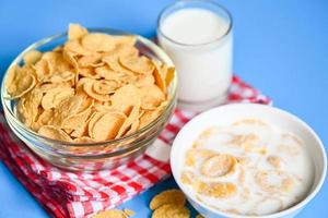 cornflakes bowl breakfast food and snack for healthy food concept, morning breakfast fresh whole grain cereal, cornflakes with milk on blue background photo