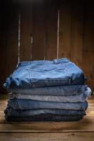 jeans stacked wood background photo