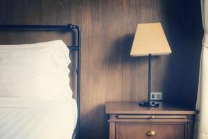 Abstract hotel bedroom with lamp and hotel bed with space for text photo