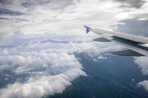 Wing of an airplane flying above the clouds photo