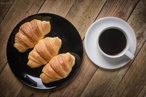 Delicious croissants on plate and coffee cup photo