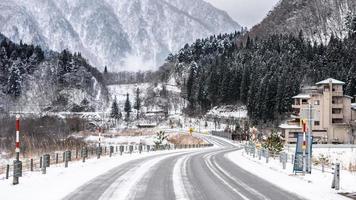 carretera cubierta de nieve vacía en el paisaje invernal foto