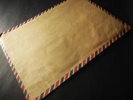 brown envelope and brown cover book on a black background photo