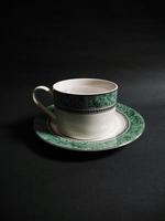 teacup filled with mineral water on black background photo
