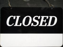 Closed signboard black and white color with a symbol that means Shop is closed. Hanging on a wooden wall. photo