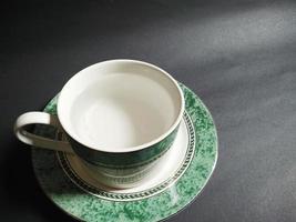 taza de té llena de agua mineral sobre fondo negro foto