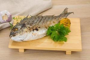 Grilled dorado on wooden board and wooden background photo