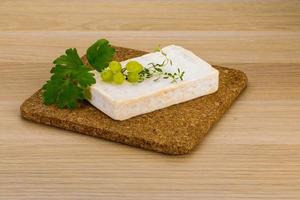 Brie cheese on wooden board and wooden background photo