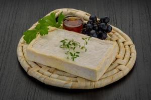 Brie cheese on wooden board and wooden background photo