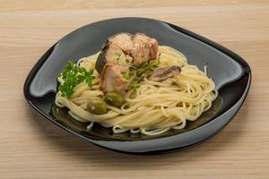 Pasta with salmon on the plate and wooden background photo