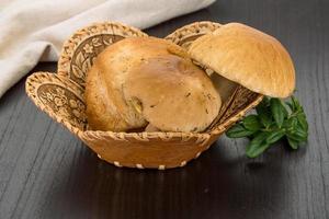 Boletus mushroom in a basket on wooden background photo