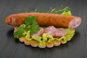 Sausage on wooden board and wooden background photo