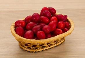 Cornus in a basket on wooden background photo