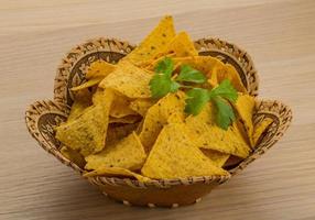 Nachos in a basket on wooden background photo