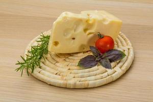 Maasdam cheese on wooden board and wooden background photo