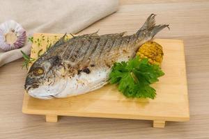 Grilled dorado on wooden board and wooden background photo