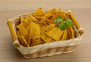 Nachos in a basket on wooden background photo