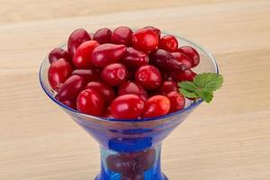 Cornus in a bowl on wooden background photo