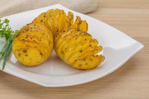 Baked potato on the plate and wooden background photo