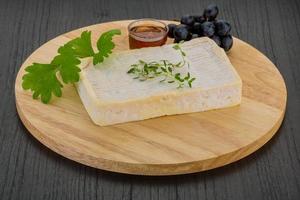 Brie cheese on wooden board and wooden background photo