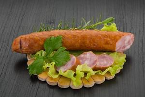 Sausage on wooden board and wooden background photo