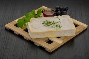 Brie cheese on wooden board and wooden background photo