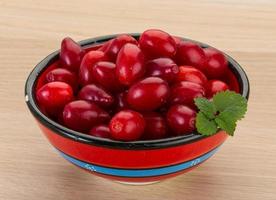 Cornus in a bowl on wooden background photo