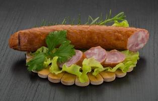 Sausage on wooden board and wooden background photo