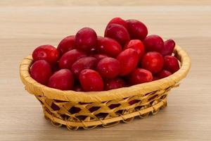 Cornus in a basket on wooden background photo