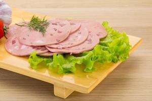 Beef sausage on wooden board and wooden background photo