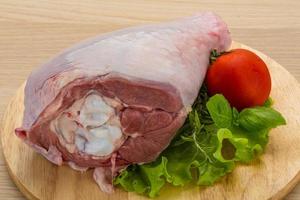 Turkey leg on wooden board and wooden background photo