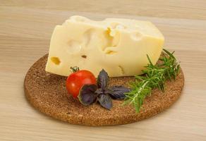 Maasdam cheese on wooden board and wooden background photo