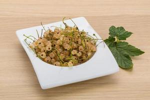 White currant in a bowl on wooden background photo