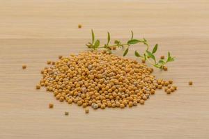 Mustard seeds on wooden background photo