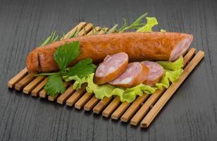 Sausage on wooden board and wooden background photo
