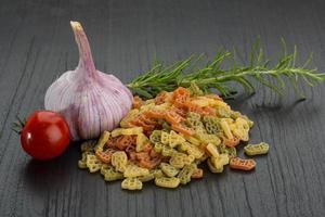 Colored pasta on wooden background photo