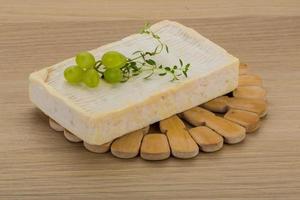 Brie cheese on wooden board and wooden background photo