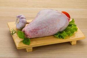 Turkey leg on wooden board and wooden background photo