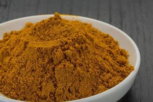 Curry powder on wooden background photo