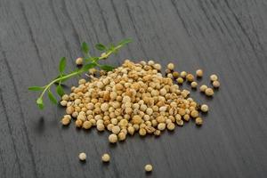 Coriander seeds on wooden background photo