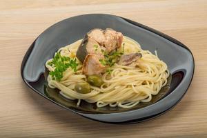 Pasta with salmon on the plate and wooden background photo