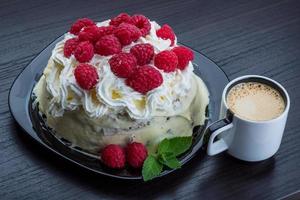 Coffee with raspberry cake on the plate close up view photo