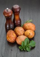 Raw potato on wooden background photo