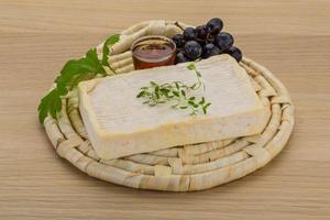 queso brie sobre tablero de madera y fondo de madera foto