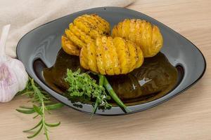 patata al horno en el plato y fondo de madera foto