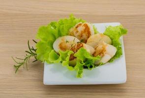 Grilled scallops in a bowl on wooden background photo