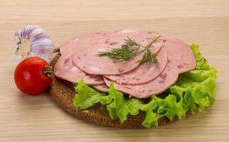 Beef sausage on wooden board and wooden background photo