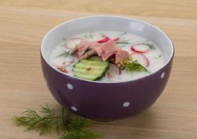 Okroshka in a bowl on wooden background photo