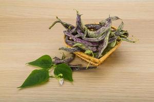 Beans with leaf in a basket on wooden background photo