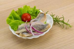 Herring fillet on the plate and wooden background photo